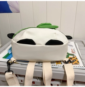 Detail of the adjustable shoulder straps and panda ear design on the white backpack