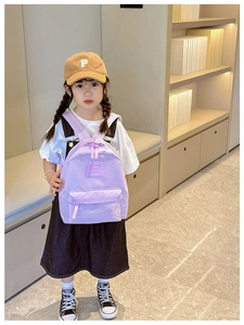 Detailansicht eines lila Kinderrucksacks mit Girl Cats Prägung getragen von einem Kind