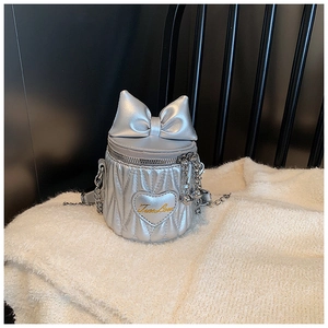 Detailed shot of silver cylindrical bucket bag with bow and True Love embroidery