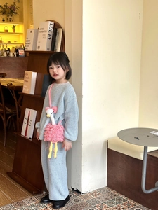 Close-up of handmade crochet ostrich bag with knit two-piece outfit for kids