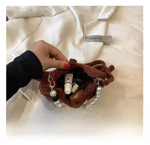 Internal capacity of brown crochet bag with pearl handle and daily essentials