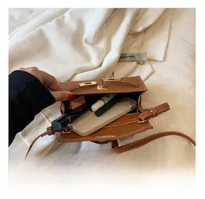 Internal view of brown leather mini bag showing capacity for phone and lipstick