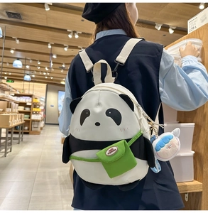 Detailed close-up of a cute panda canvas backpack with a mini green pocket and charm