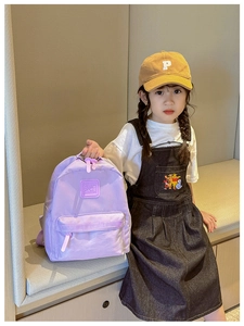 Detail eines hellvioletten Kinderrucksacks mit GIRL CATS Label und Reißverschluss