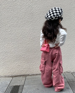 Girl in pink cargo pants and white top with a matching pink mini top-handle handbag