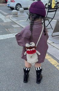 Detail of handmade crochet cartoon bag featuring large red lips and brown hair decoration