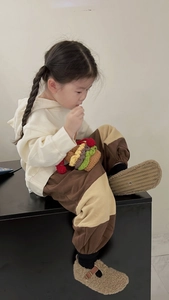 Detail of a handmade knit burger-shaped drawstring bucket bag on a child outfit
