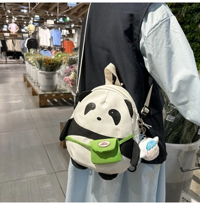 Detail of cute panda backpack featuring a green mini pocket and plush charm on canvas