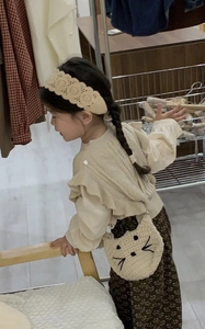 Little girl wearing a crochet cat crossbody bag with floral dress and lace headband