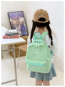 Rückansicht eines Kindes mit leichtem minzgrünem Kindergarten-Rucksack mit Logo
