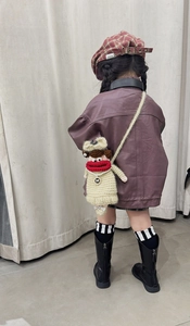 Detail of a handmade crochet crossbody bag with funny red lips on a child model