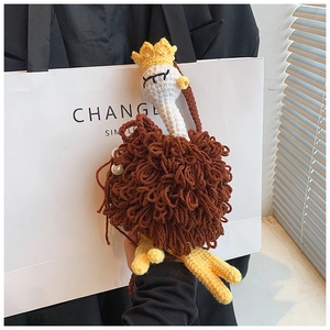 Close-up of handmade crochet ostrich bag charm featuring soft wool texture and yellow crown