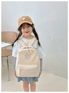Detail eines beigen Kinderrucksacks aus Segeltuch mit Girl Cats Patch für Mädchen