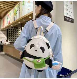 Detail of cute panda backpack with plush charm and side pocket shown on a model back