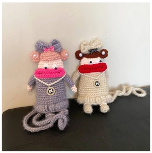 Detail of handmade crochet doll bags featuring large lips and polka dot bows