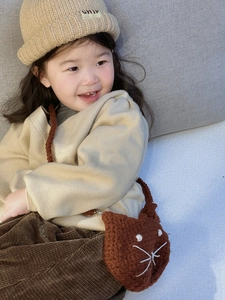 Detail of hand-crocheted brown cat shoulder bag for girls with soft knitted texture