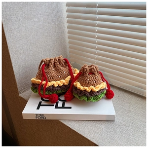Close-up of handmade crochet burger drawstring bags with detailed knit texture and pom-poms