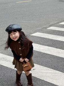 Outdoor shot of a girl wearing a brown knitted vest and matching mini handbag
