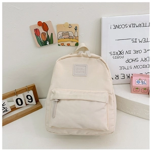 Detailansicht eines cremefarbenen Kinderrucksacks mit Girl Cats Logo und Reißverschlusstasche