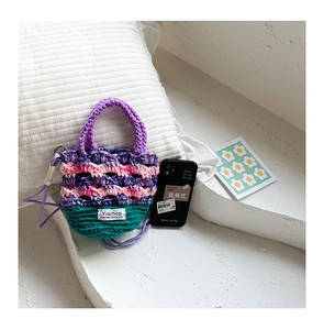Vue macro détaillée du mini sac au crochet fait main coloré avec texture tissée et sangle