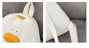 Close-up of cute cartoon chick backpack showing embroidery eyes and leather beak detail