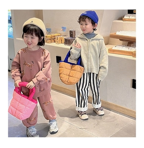 Enfants portant des sacs matelassés d'automne avec streetwear et bonnets décontractés