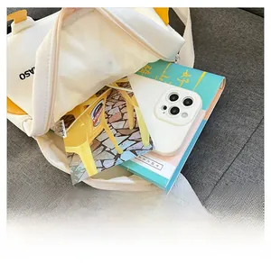 Detail view of the spacious inner compartment of the white canvas chick backpack