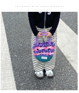 Détail de sac au crochet fait main montrant la texture tricotée et la anse violette