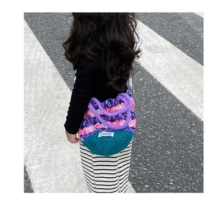 Vue détaillée du sac au crochet multicolore fait main montrant les textures de tricot