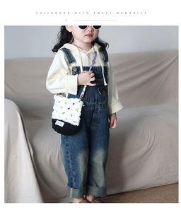 Sac pour enfant crocheté à la main en noir et blanc avec bandoulière violette sur modèle