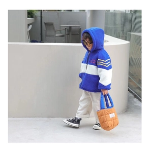 Détail du sac à bandoulière en nylon matelassé avec grande étiquette en tissu pour enfants