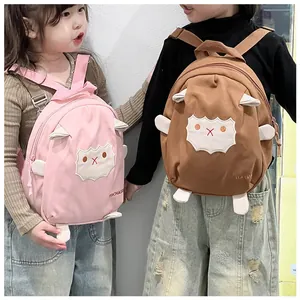 Süße Cartoon-Lamm-Rucksäcke für Kinder in Rosa und Braun, getragen von Kleinkindern im Alltag