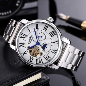 Detailed view of white dial automatic watch with moon phase and open heart on leather book