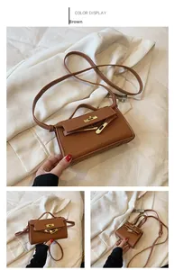 Detail of brown litchi pattern mini bag with gold twist lock and crossbody strap