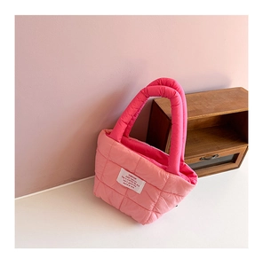 Détail du sac à main en nylon matelassé rose avec patch carré et design bicolore élégant