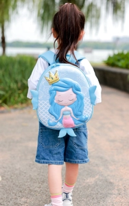 Detail of 3D mermaid hardshell backpack on a child in an outdoor park setting