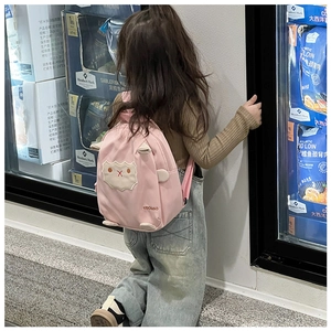 Kleinkind zeigt leichten rosa Cartoon-Schaf-Rucksack mit 3D-Ohren im Supermarkt