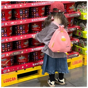 Rear view of a child wearing the cute pink cartoon chick backpack in a grocery aisle