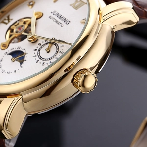 Macro view of automatic mechanical watch with gold case, moon phase dial and leather strap