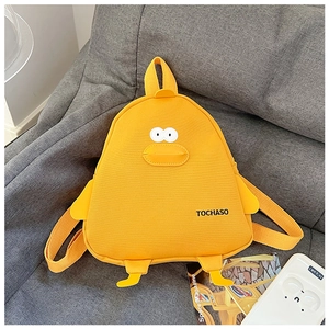 Detail of yellow cartoon duck canvas backpack with 3D wings and feet on gray sofa