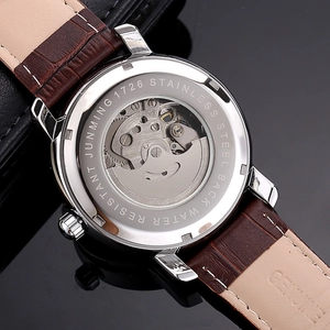 Macro shot of transparent case back showing automatic mechanical watch movement and leather strap
