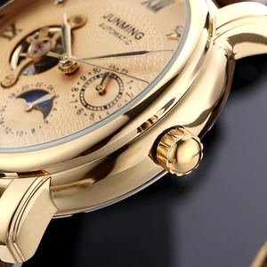 Macro shot of gold automatic watch dial with moon phase and tourbillon details