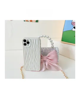 Detail of pink sequin mini bag with silk bow, pearl handle, and gold chain for girls