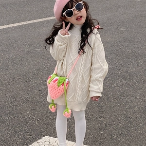 Girl in white cable-knit sweater with a handmade pink crochet strawberry crossbody bag