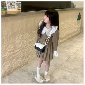 Détail d'une robe marron plissée pour fille avec col en dentelle blanche et petit sac