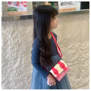 Détail de la sacoche bicolore rose et rouge pour filles avec un pompon en fourrure