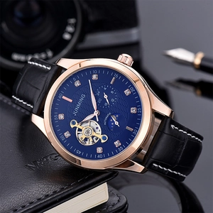 Detailed close-up of a blue sunburst dial mechanical watch with rose gold case and leather strap