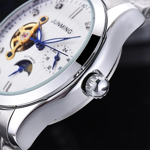 Detailed close-up of white sunray dial with blue hands and open heart flywheel
