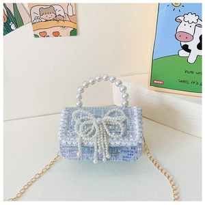 Detail of blue tweed girls handbag with pearl bow, lace trim and pearl handle