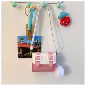 Détail du sac bandoulière rose et blanc avec pompon en peluche et boucles décoratives